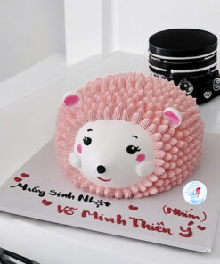 bánh kem con nhím với tạo hình đáng yêu, tone hồng nhẹ nhàng, mang đến cảm giác ấm áp và dễ thương,